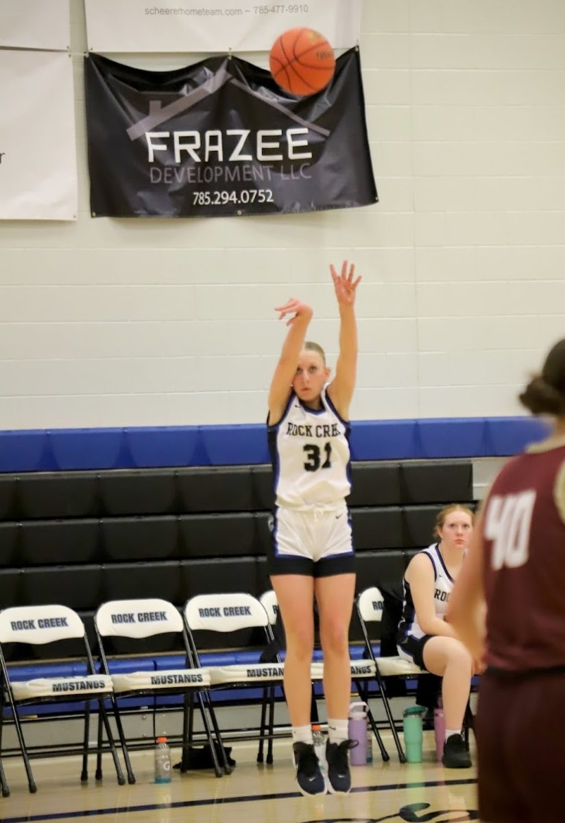 Shooting a three, freshman Karli Reitz sinks the ball for the Mustangs and ultimately leads her team to a victory over Silverlake on January 28, 2025. Photo Courtesy of  Sara McCarn