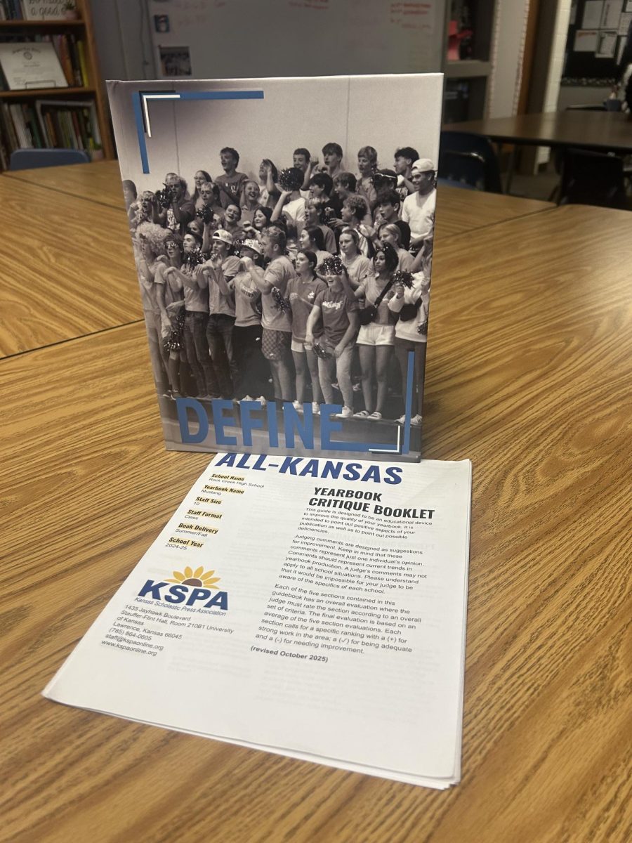 Defined by dedication. The award-winning 2024–2025 Rock Creek yearbook, DEFINE, is pictured alongside its KSPA critique guide. Judges’ detailed feedback will help guide the 2025–2026 yearbook staff as they build on last year’s success and continue to improve the publication.